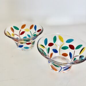 Small clear glass bowl with a flared rim, decorated with colourful leaves in red, blue, green, yellow and orange on thin green vines.