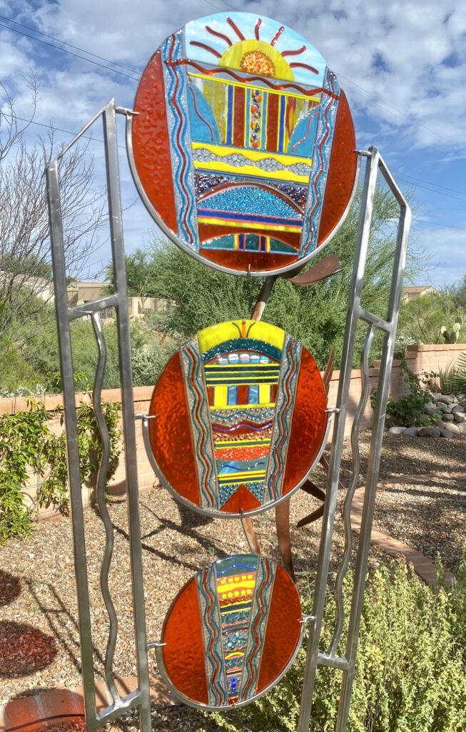 Vibrant glass pieces on stand in sunny garden